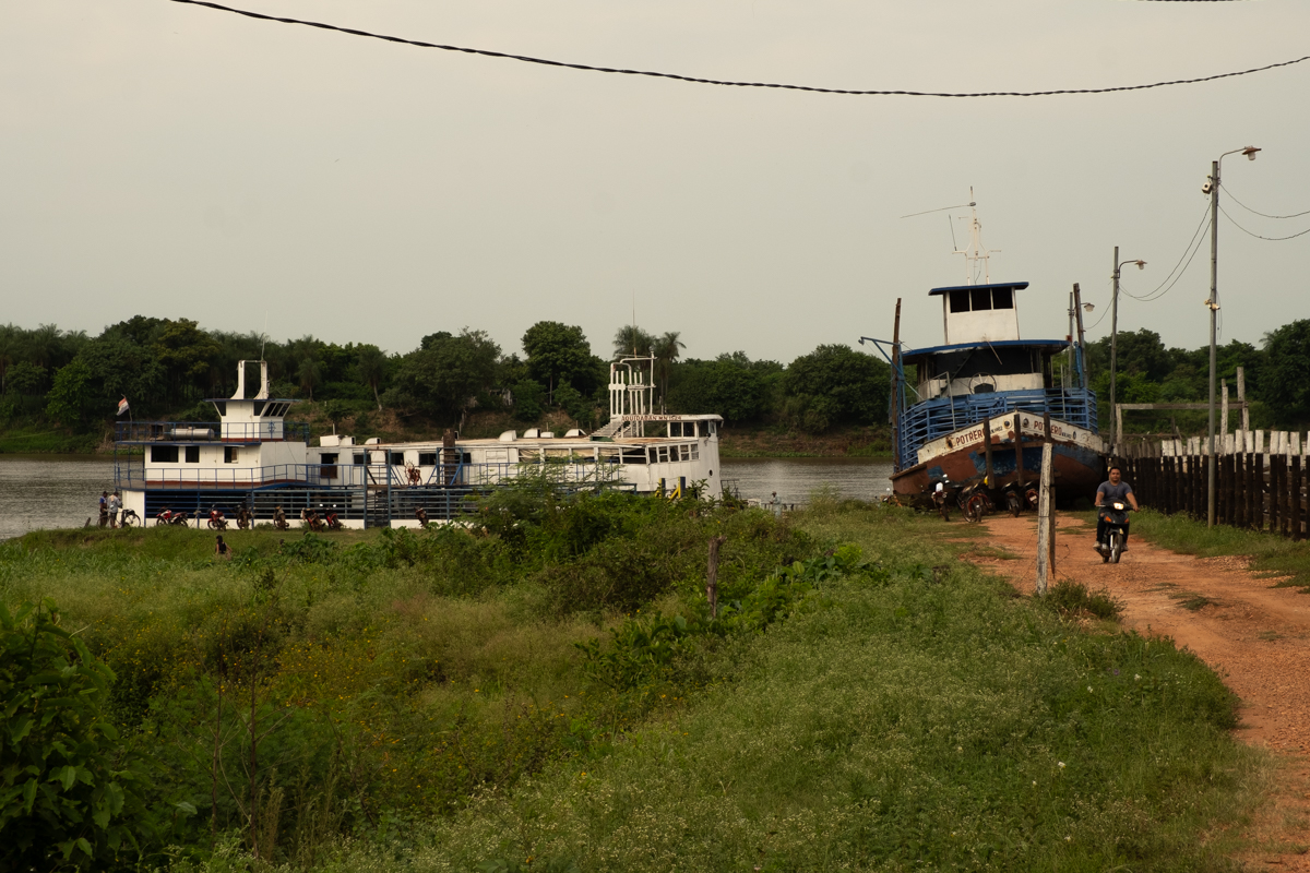 Portrait of a Pantanal fisherman sitting bare-chested in front of a tarp shelter on the Aquidaban, Paraguay