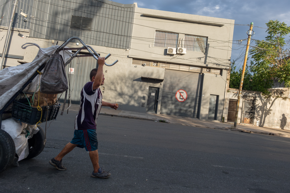 Two men rummaging through street bins in a Buenos Aires commercial district