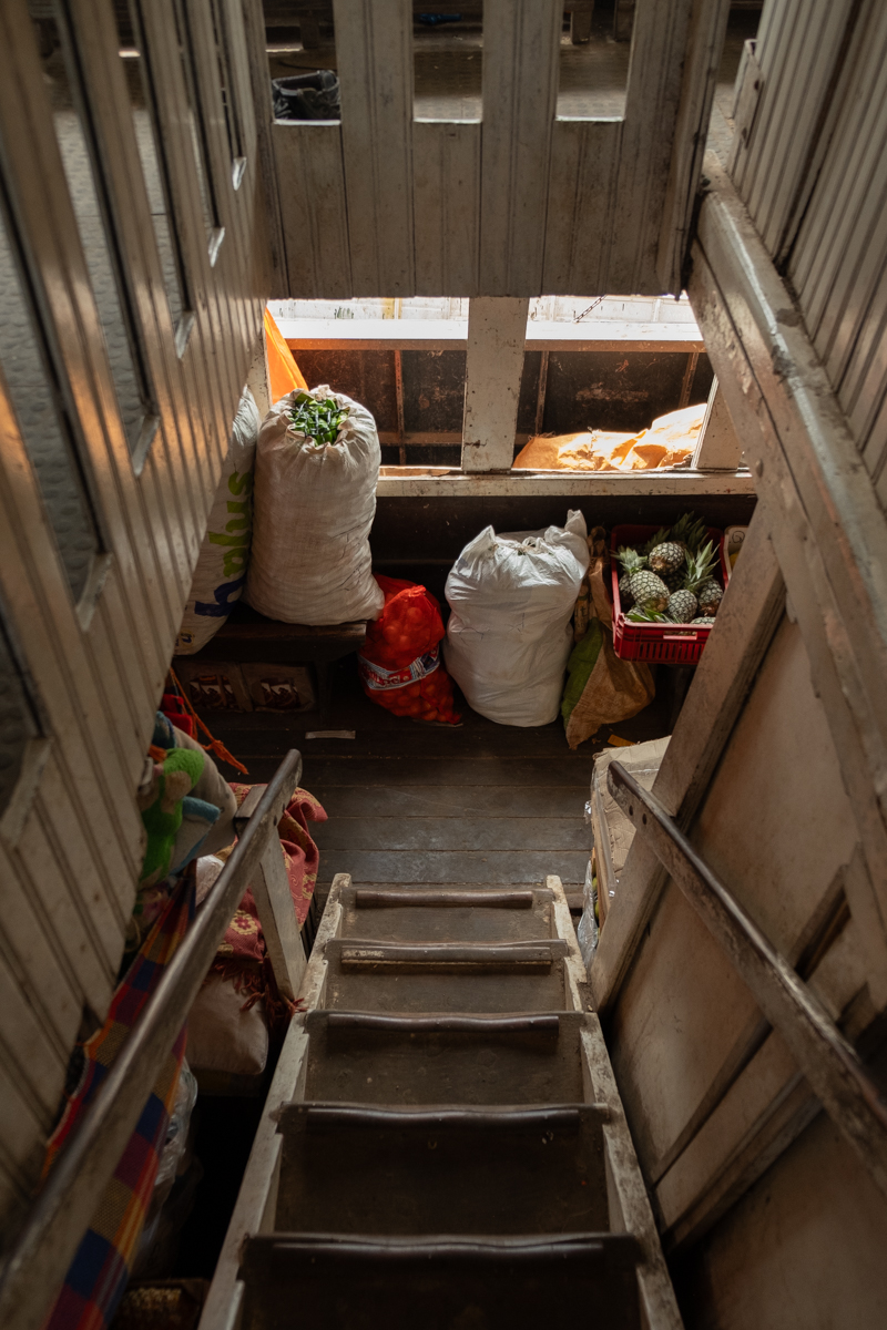 Woman drinking mate beneath colourful hammocks on the passenger deck of the Aquidaban