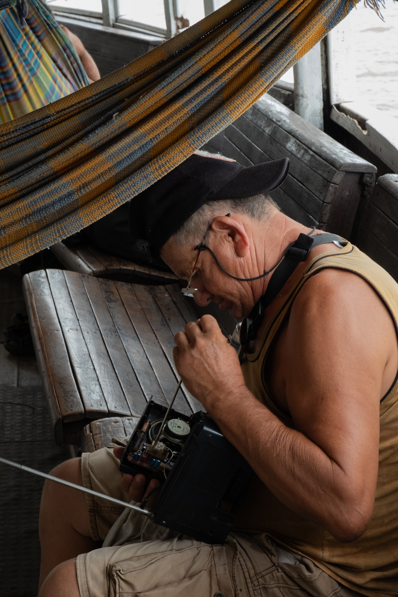 Young couple holding a newborn baby aboard the Aquidaban, looking out at the riverbank
