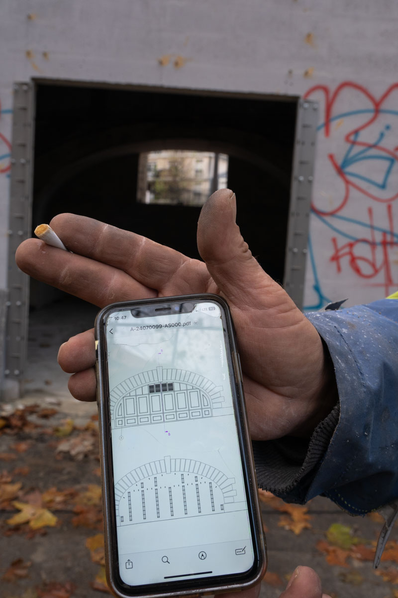 Duvet and bedding left on a ledge under a concrete overpass in Paris at night