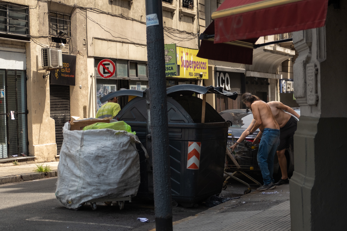 Elderly cartonero pushing an enormous load under a highway overpass, Buenos Aires