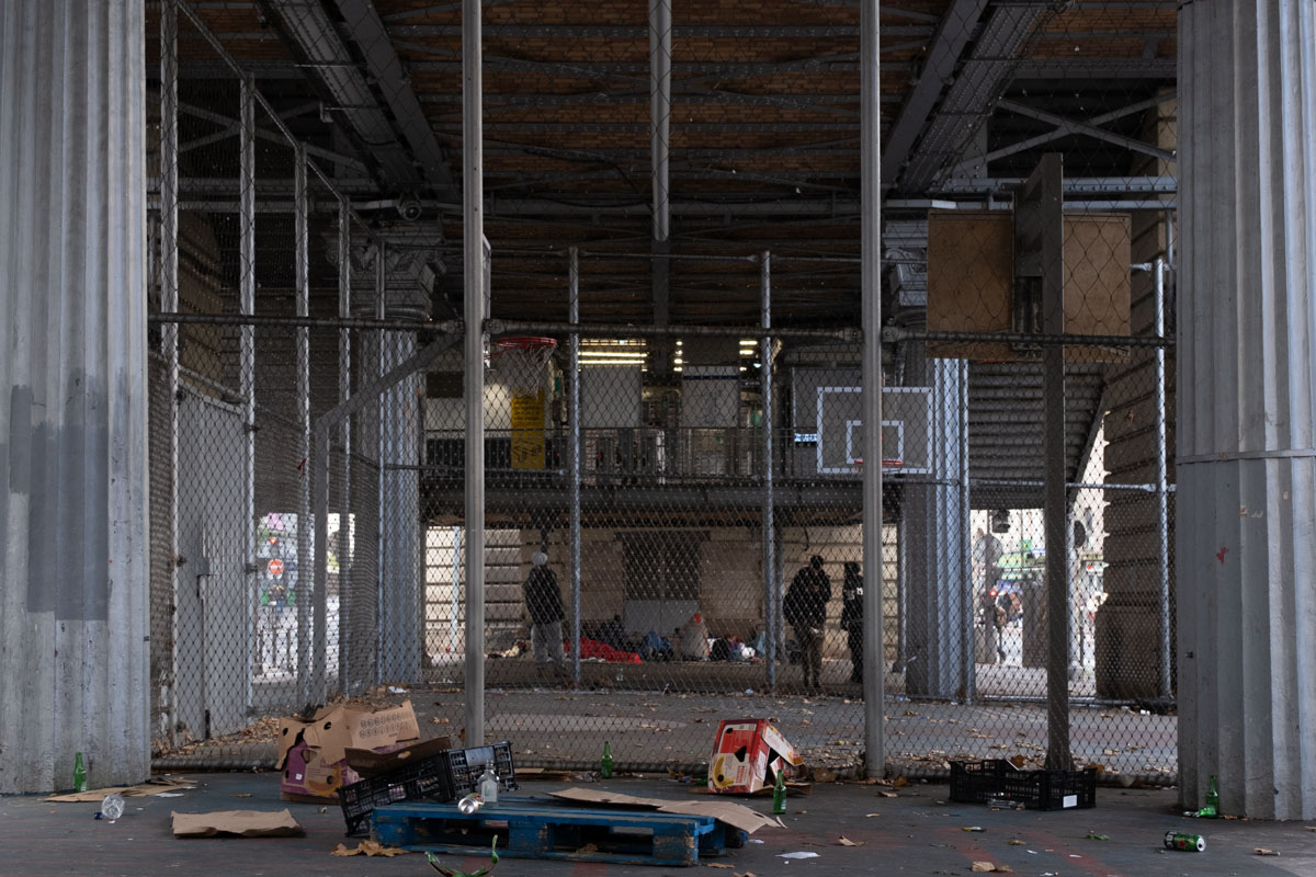 Anti-homeless seating — bowl-shaped green seats on a Paris metro platform designed to prevent lying down